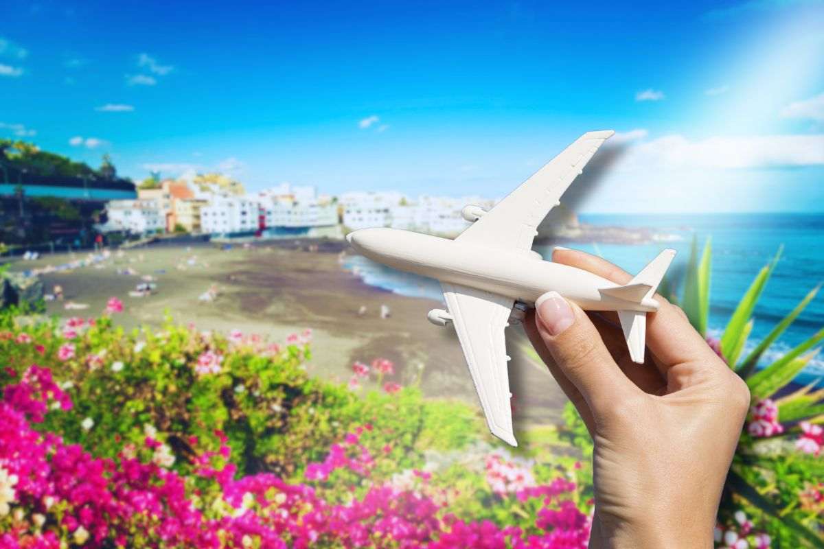 spiaggia di Tenerife sfondo e focus su aereo in mano